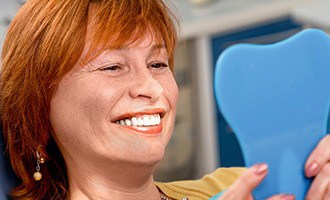 Woman admiring her new dental implants in Massapequa Park 
