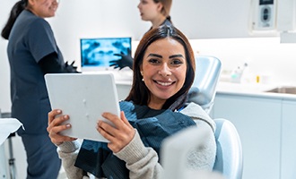 Woman smiling while holding handheld mirror