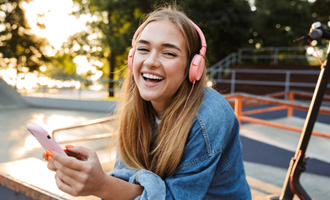 Teen girl smiling while listening to music outside