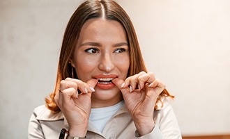 Patient putting on clear aligner in treatment room