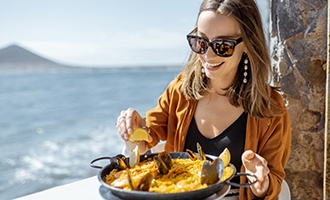 Woman smiling while enjoying lunch by the water