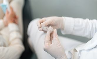 Dentist holding clear aligners
